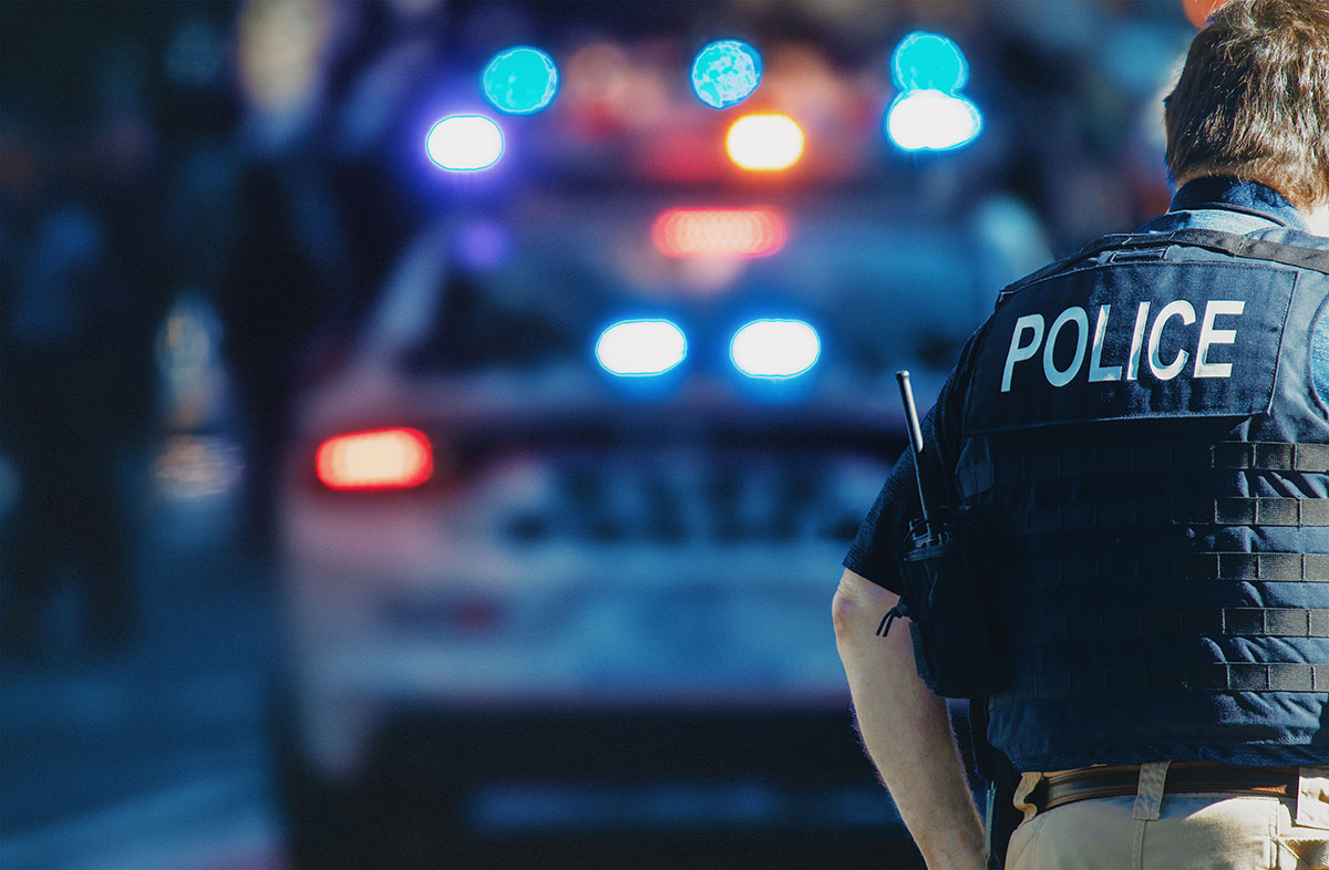 policeman in front of police car